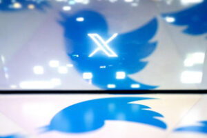Esta foto ilustrativa creada en Washington, DC, el 24 de julio de 2023, muestra el nuevo logotipo X de Twitter reflejado en el logotipo del pájaro de TwitterSTEFANI REYNOLDS/AFP