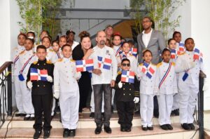 Juan Pablo Uribe, habla, al lado de los niños abanderados.