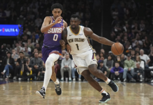 Zion Williamson, de los Pelicans de Nueva Orleáns, dribla a Ryan Dunn, de los Suns de Phoenix