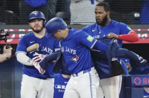 Daulton Varsho, centro, de los Azulejos de Toronto, celebra su grand slam contra los Padres de San Diego, con Vladimir Guerrero Jr., derecha, y Alejandro Kirk