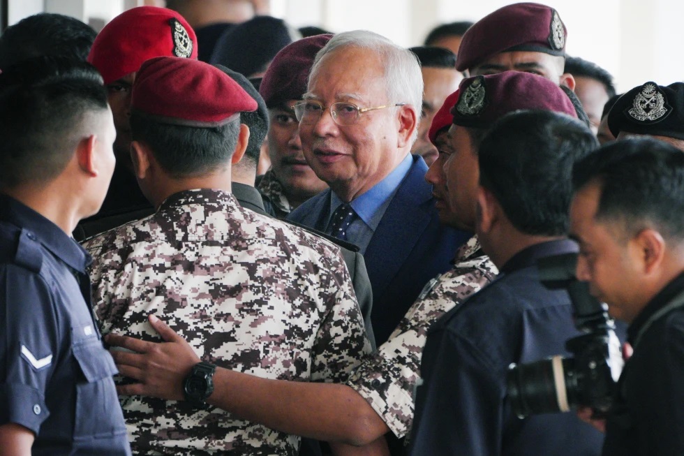 El ex primer ministro de Malasia, Najib Razak, al centro, es acompañado por agentes penitenciarios a su llegada al complejo judicial de Kuala Lumpur, el 30 de octubre de 2024, en Kuala Lumpur. (AP Foto/Vincent Thian, Archivo)