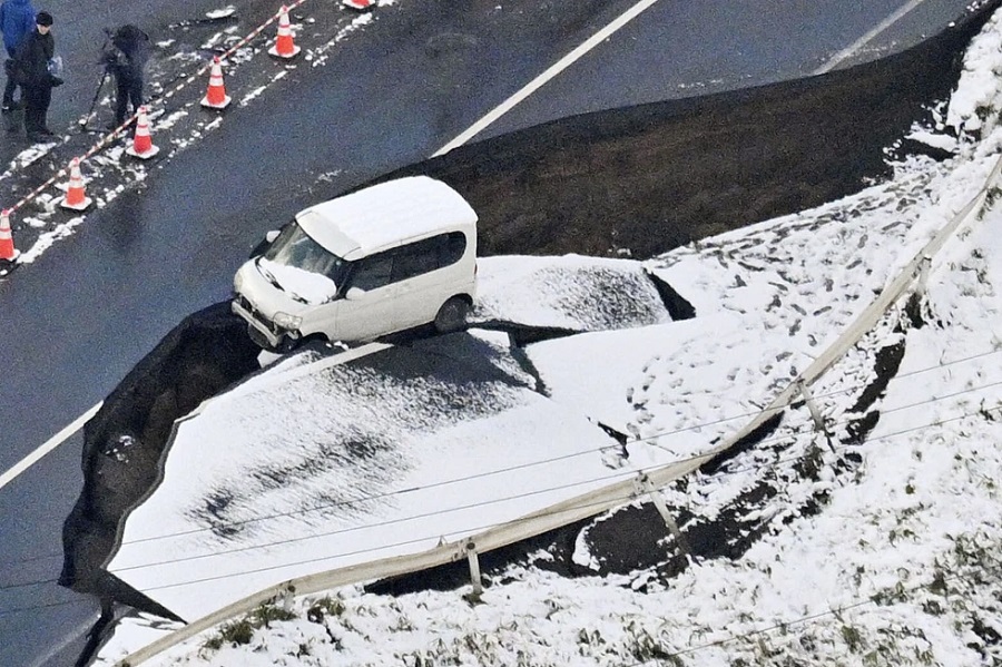 Esta foto aérea muestra un vehículo en una carretera dañada en la localidad de Tohoku, prefectura de Aomori, en el norte de Japón, el martes 9 de diciembre de 2025, tras un fuerte sismo el lunes por la noche. (Kyodo News via AP)