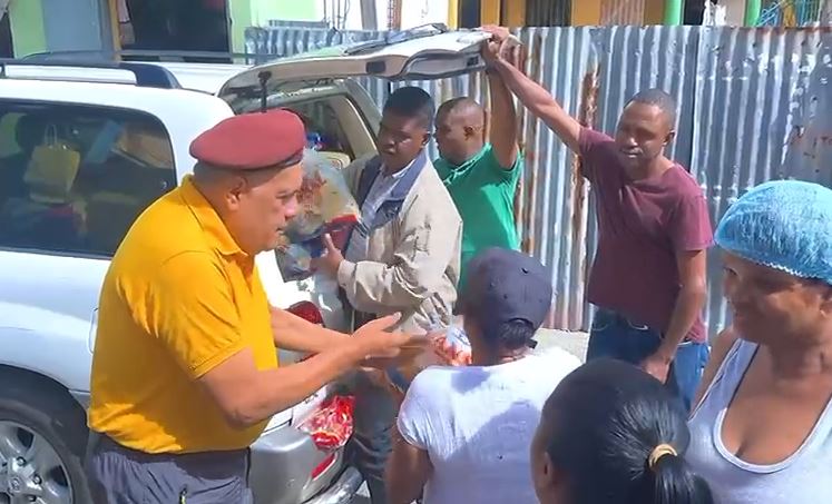 Luis “El Gallo” reparte habichuelas con dulce bajo lluvia