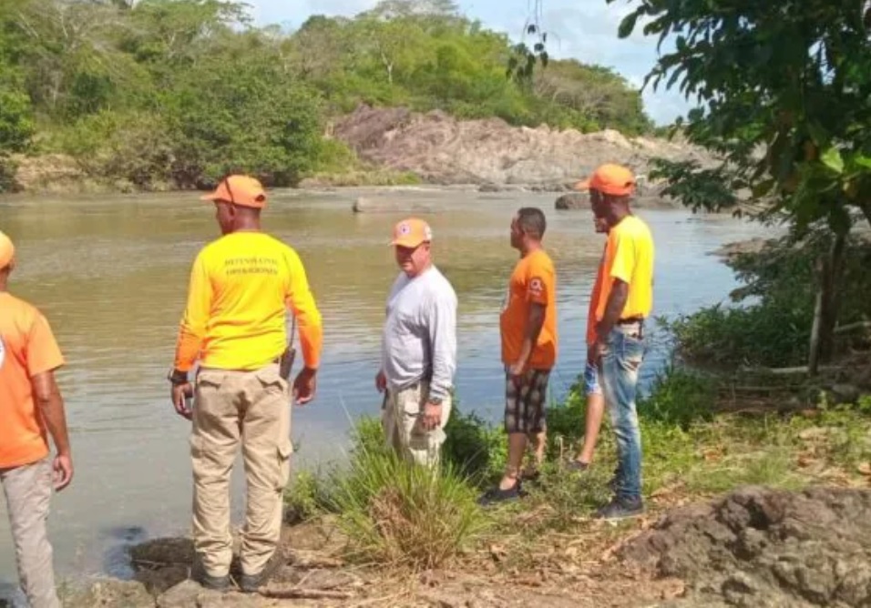 Miembros de la Defensa Civil buscan un adolescente arrastrado río Chavón el jueves